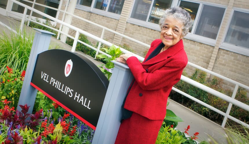 Vel Phillips standing in front of the residence hall on the UW-Madison campus named in her honor.
