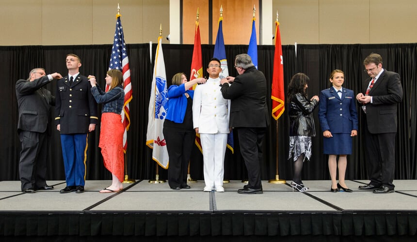 Graduates from UW-Madison's Army, Navy and Air Force ROTC units being pinned by theier family members during the officer commissioning ceremony.