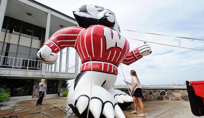 A giant inflatable Bucky Badger being cleaned by students.