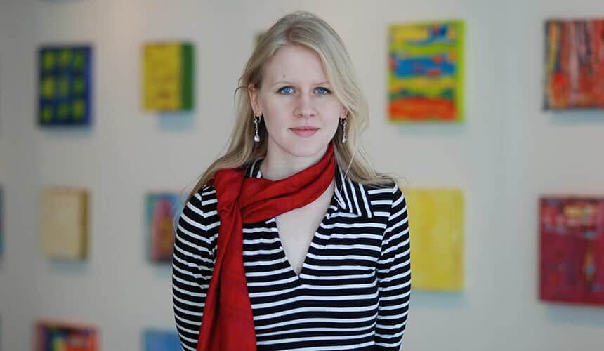 Justine Nagan was a recipient of a 2012 Forward under 40 Award from the Wisconsin Alumni Association.(Photo courtesy of Justine Nagan.) Justine Nagan standing in front of a wall of art.