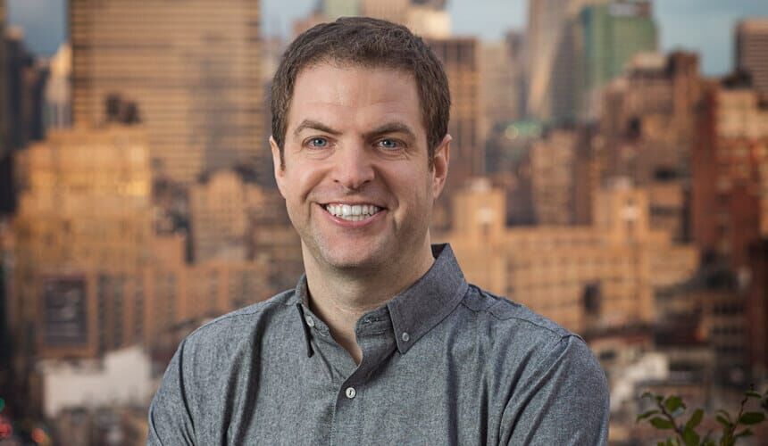 Ben Relles portrait with city skyline background.