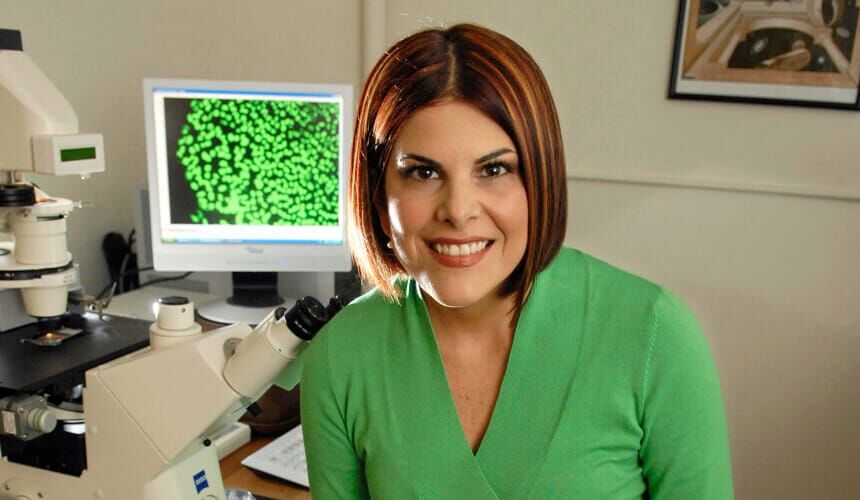 Cezar smiling, while near her lab equipment.