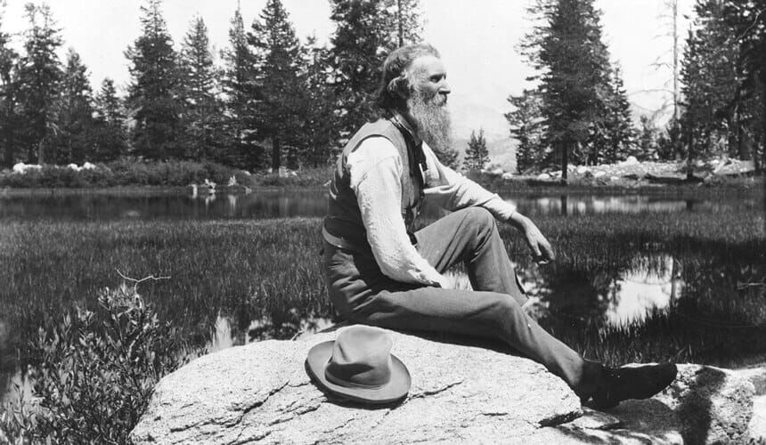 Muir sitting on a rock.