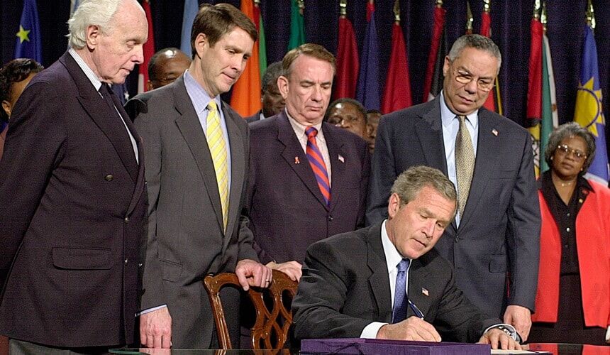 President George W. Bush signs the $15 billion U.S. Leadership Against HIV/AIDS Act of 2003, when Tommy Thompson was Health and Human Services Secretary.