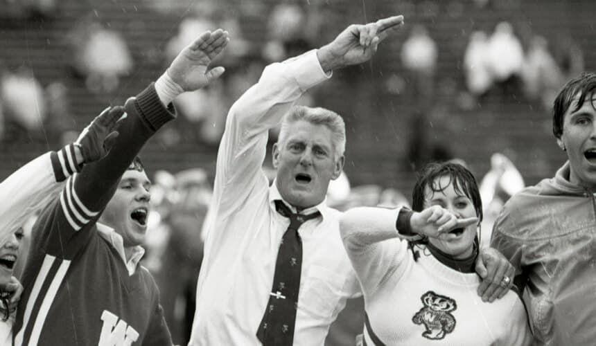 UW alum, football player and athletic director, Elroy "Crazylegs" Hirsch leads fans in singing "Varsity". (Image courtesy of the UW Digital Collections.) UW alum, football player and athletic director, Elroy "Crazylegs" Hirsch leads fans in singing "Varsity".
