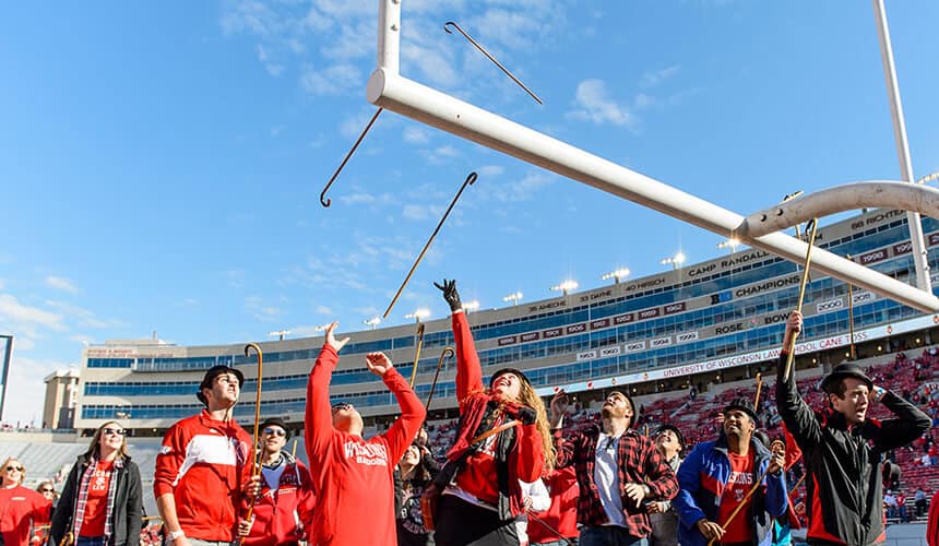 Students tossing canes through the field goal post.