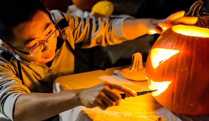 Person lighting up jack-o-lantern