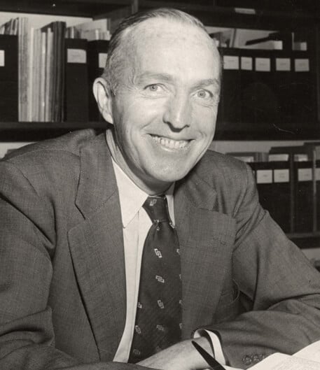Hickey smiling, while at his desk.