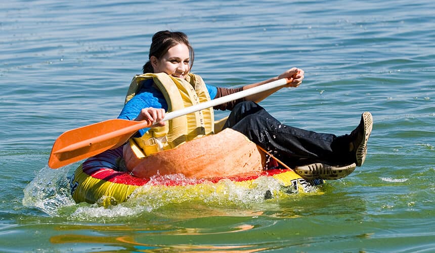Participant trying to stay afloat on top of a pumpkin