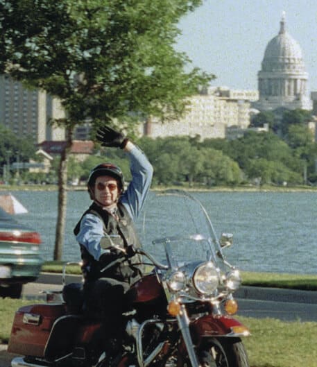 Tommy Thompson waves on his Harley-Davidson.